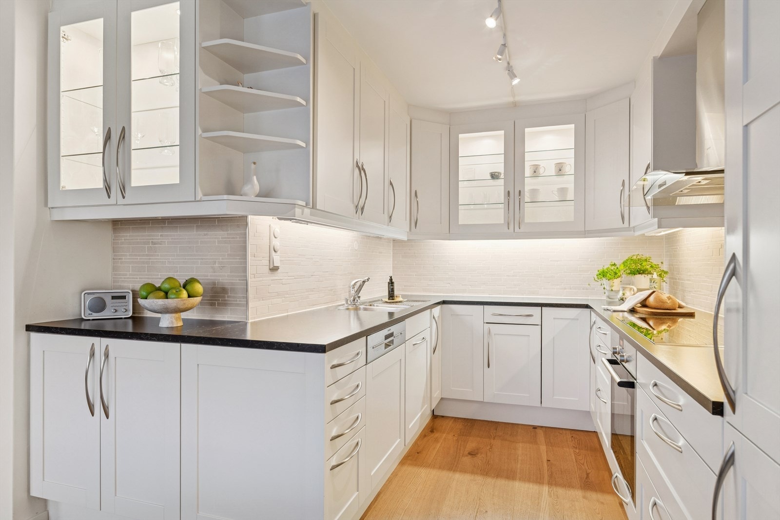 Pent kjøkken fra 2010 med profilerte fronter, benkeplate i laminat og nedfelt kum av stål med blandebatteri Galleribilde