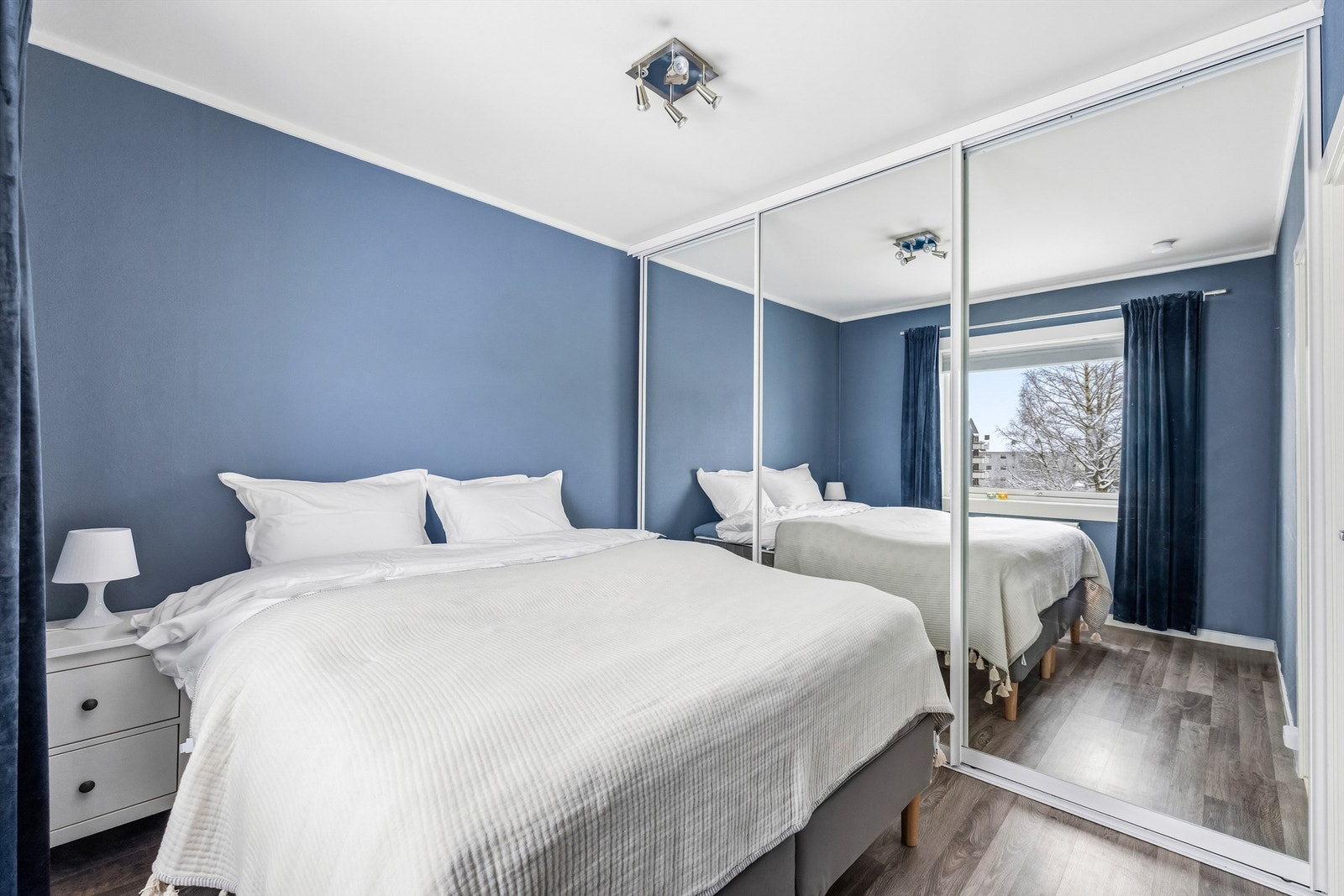 En stor skyvedørsgarderobe med speilfronter gir rikelig med oppbevaringsplass. Galleribilde