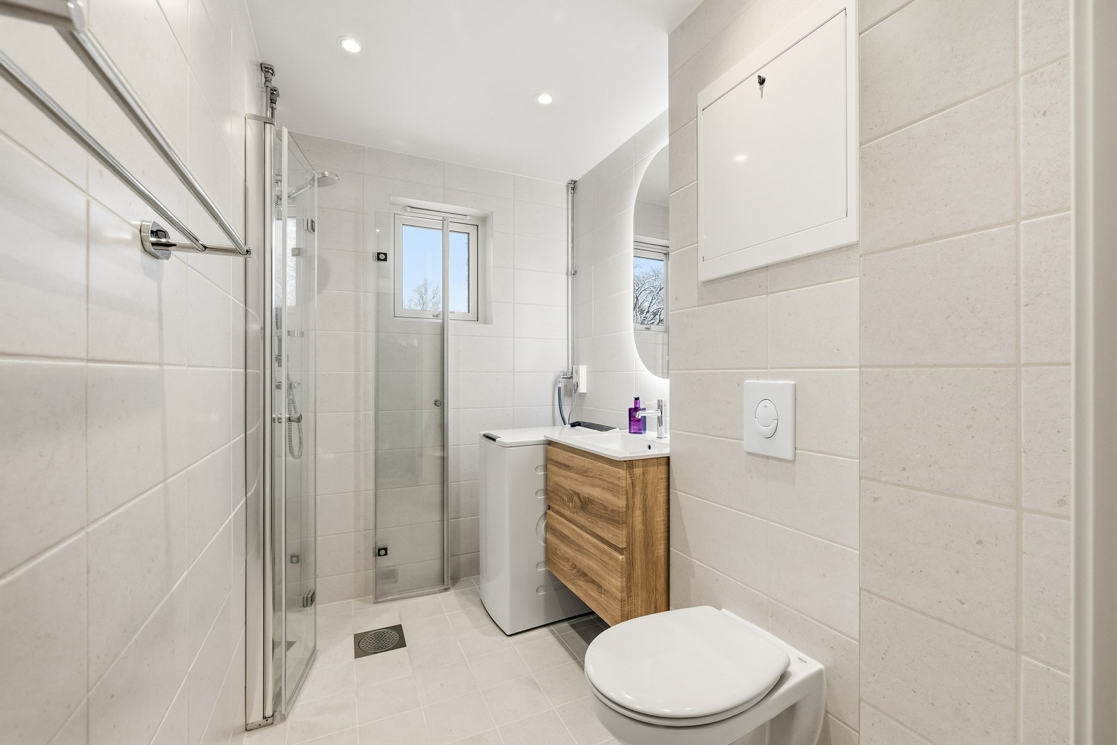 Badet har vegghengt toalett og opplegg for vaskemaskin. Galleribilde