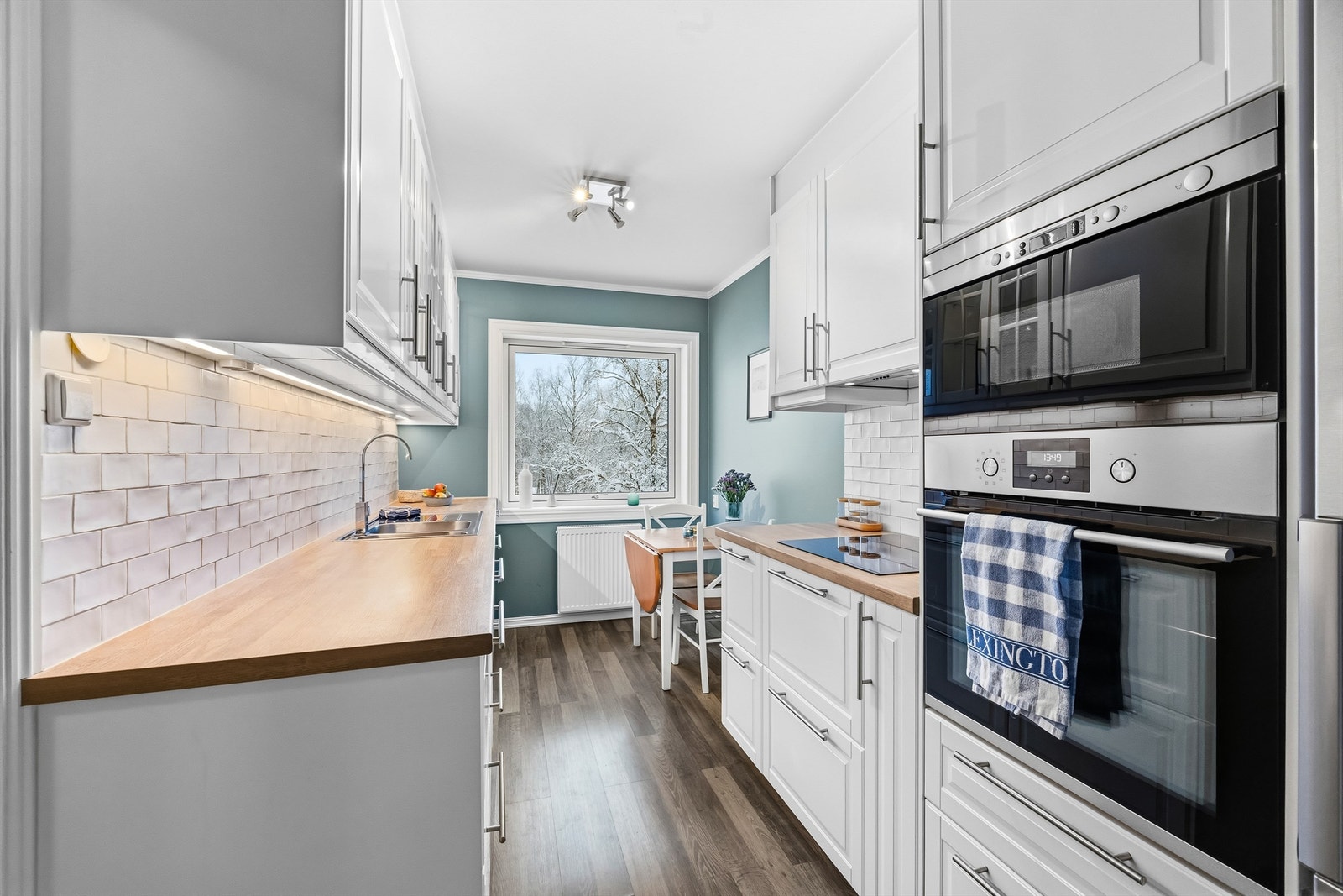 Innbydende kjøkken med integrerte hvitevarer som stekeovn, mikro, koketopp og oppvaskmaskin Galleribilde