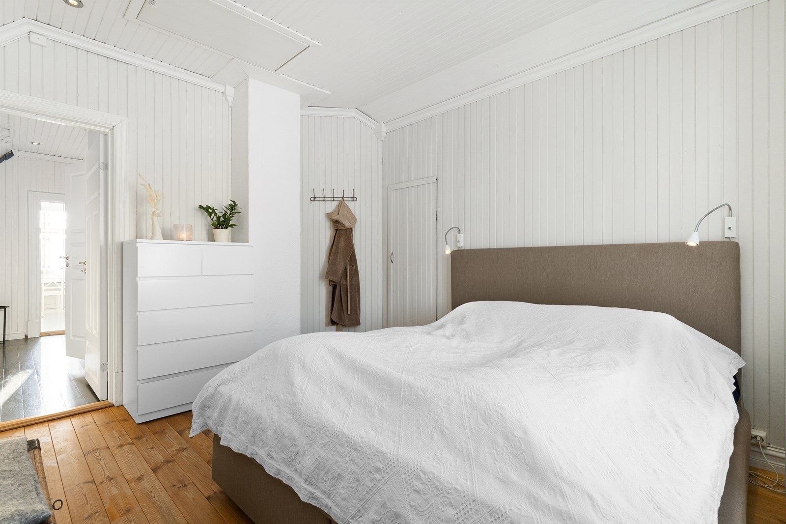 Etasjen har god takhøyde og lyse overflater, som gir luftige rom med god atmosfære. I kneveggene har man ekstra garderobeplass eller lagringsplass på egne kneloft. Det er også takluke opp til loftet fra dette soverommet. Galleribilde