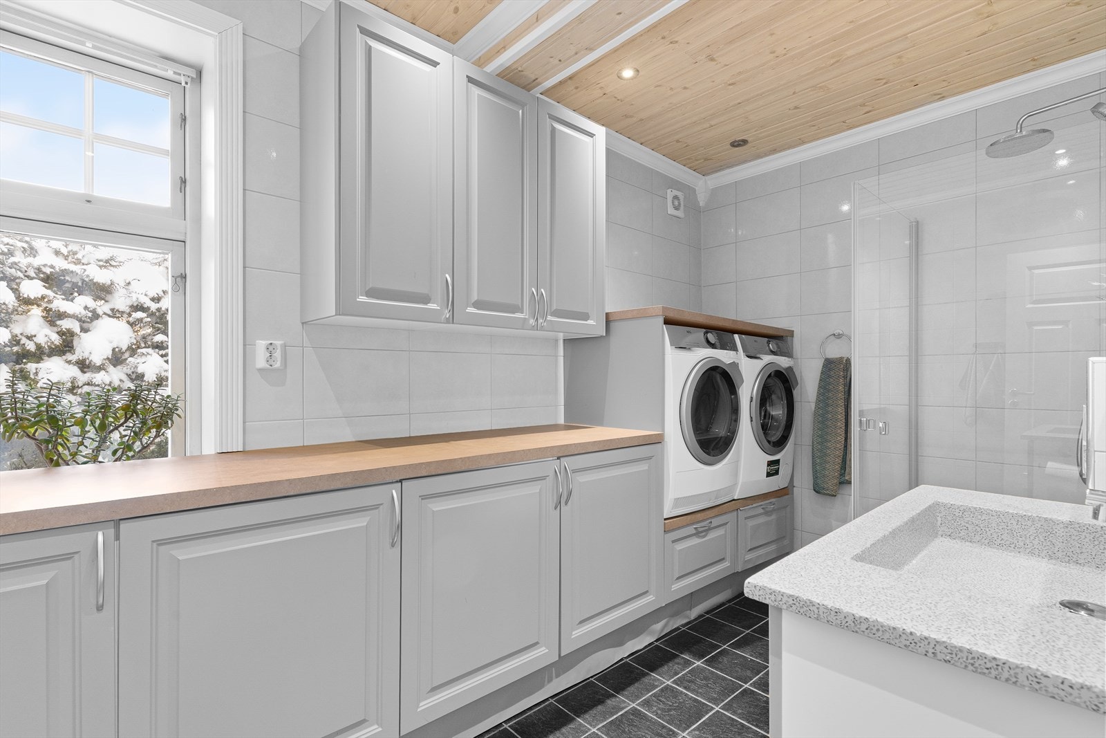 Rommet er dessuten utstyrt med en raus arbeidsbenk, med egen nisje for plass til vaskemaskin og tørketrommel i behagelig arbeidshøyde. Galleribilde