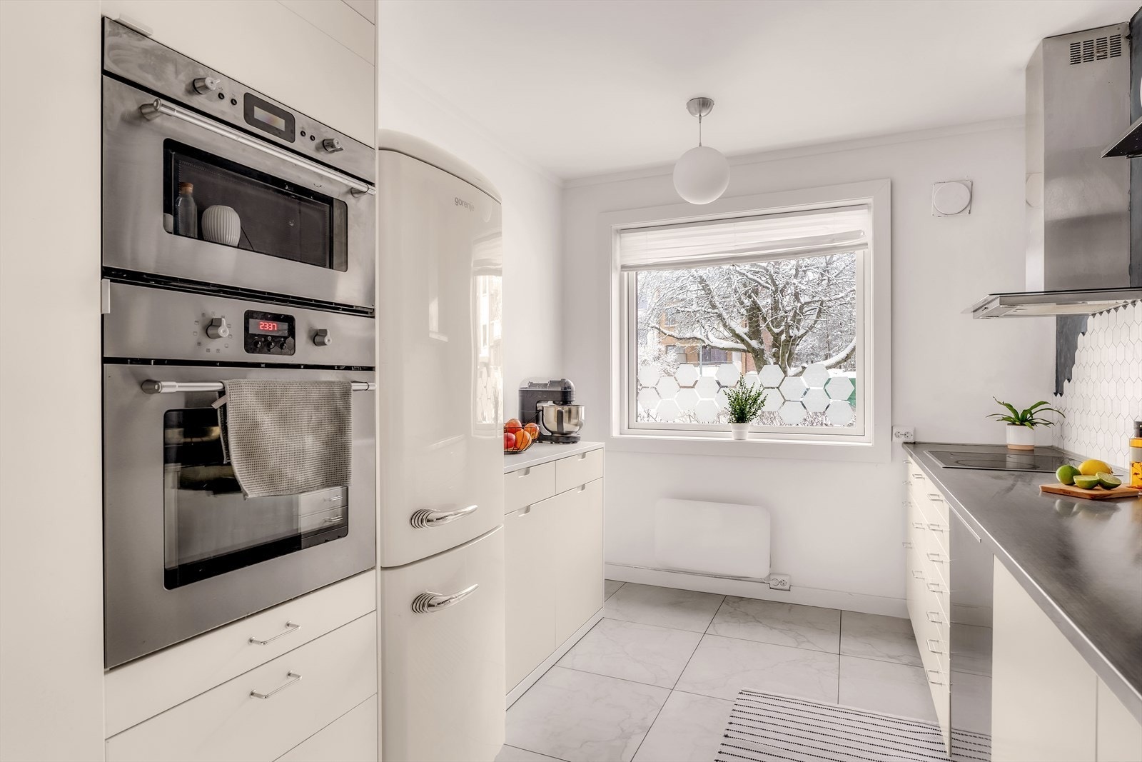 Separat kjøkken med slette fronter og benkeplate i stål. Galleribilde