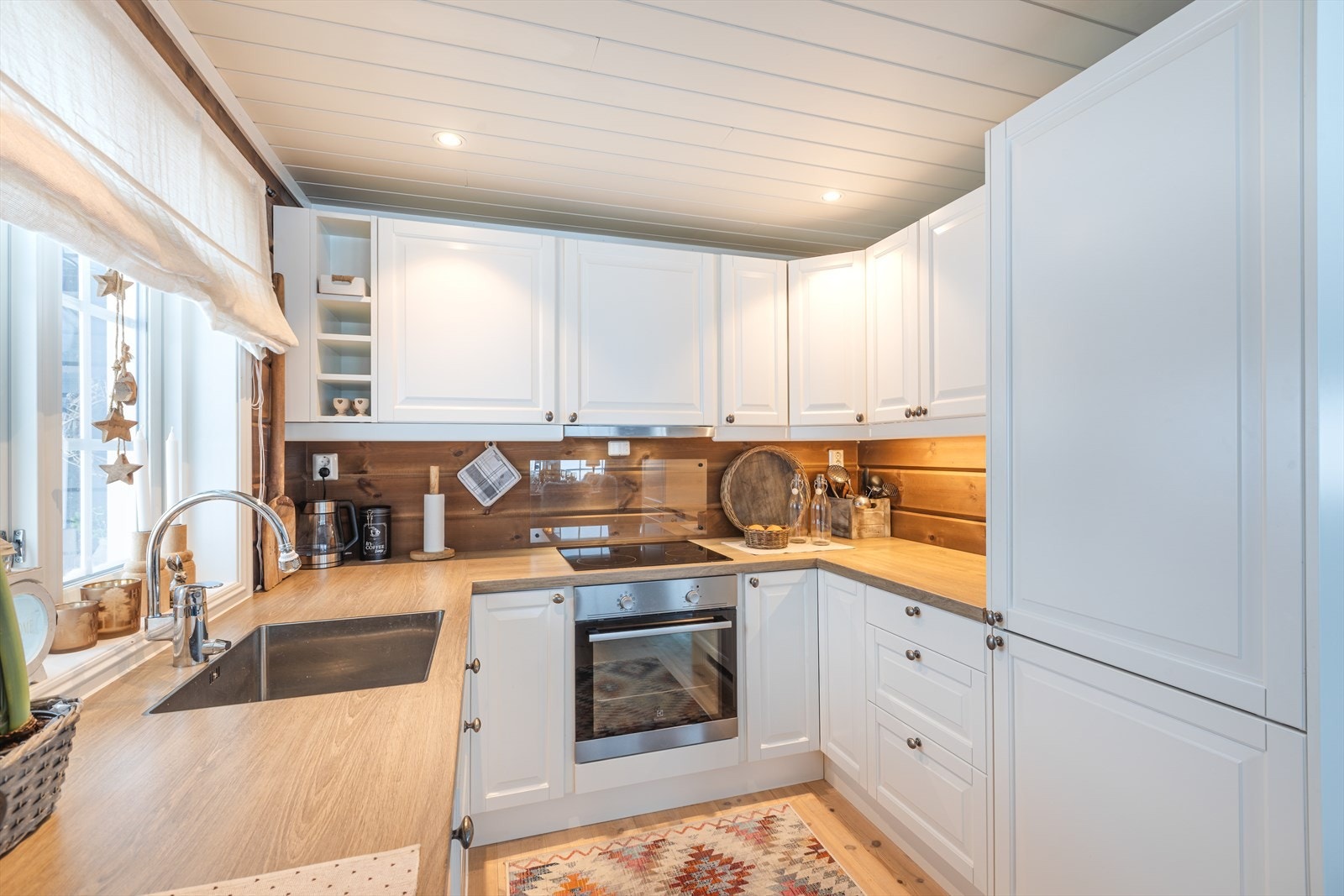 Integrert kjøleskap og oppvaskmaskin gir en helhetlig kjøkkenløsning med praktisk benkeplass. Galleribilde