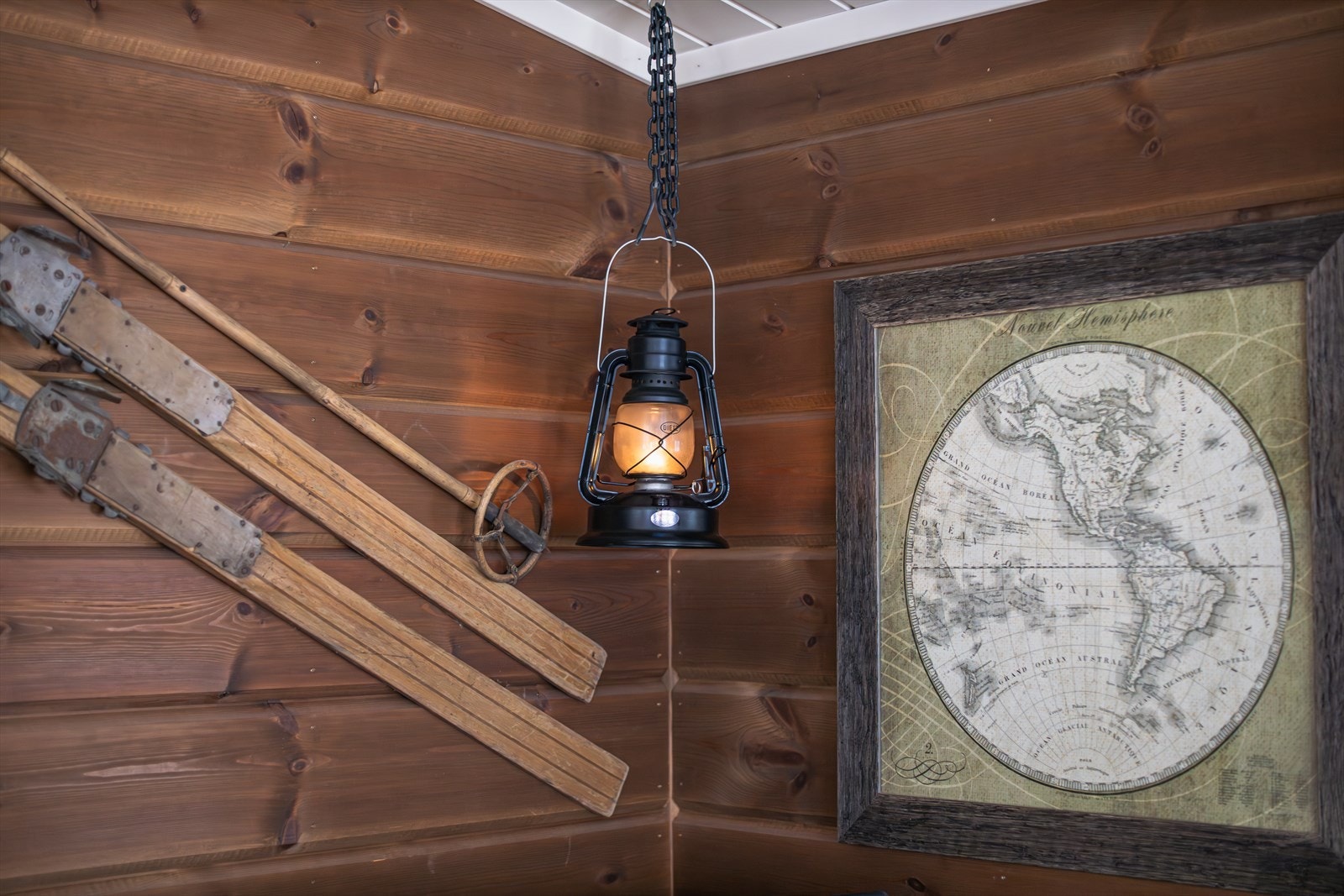 Tradisjonelle ski og en hengende lanterne skaper en rustikk atmosfære. Galleribilde