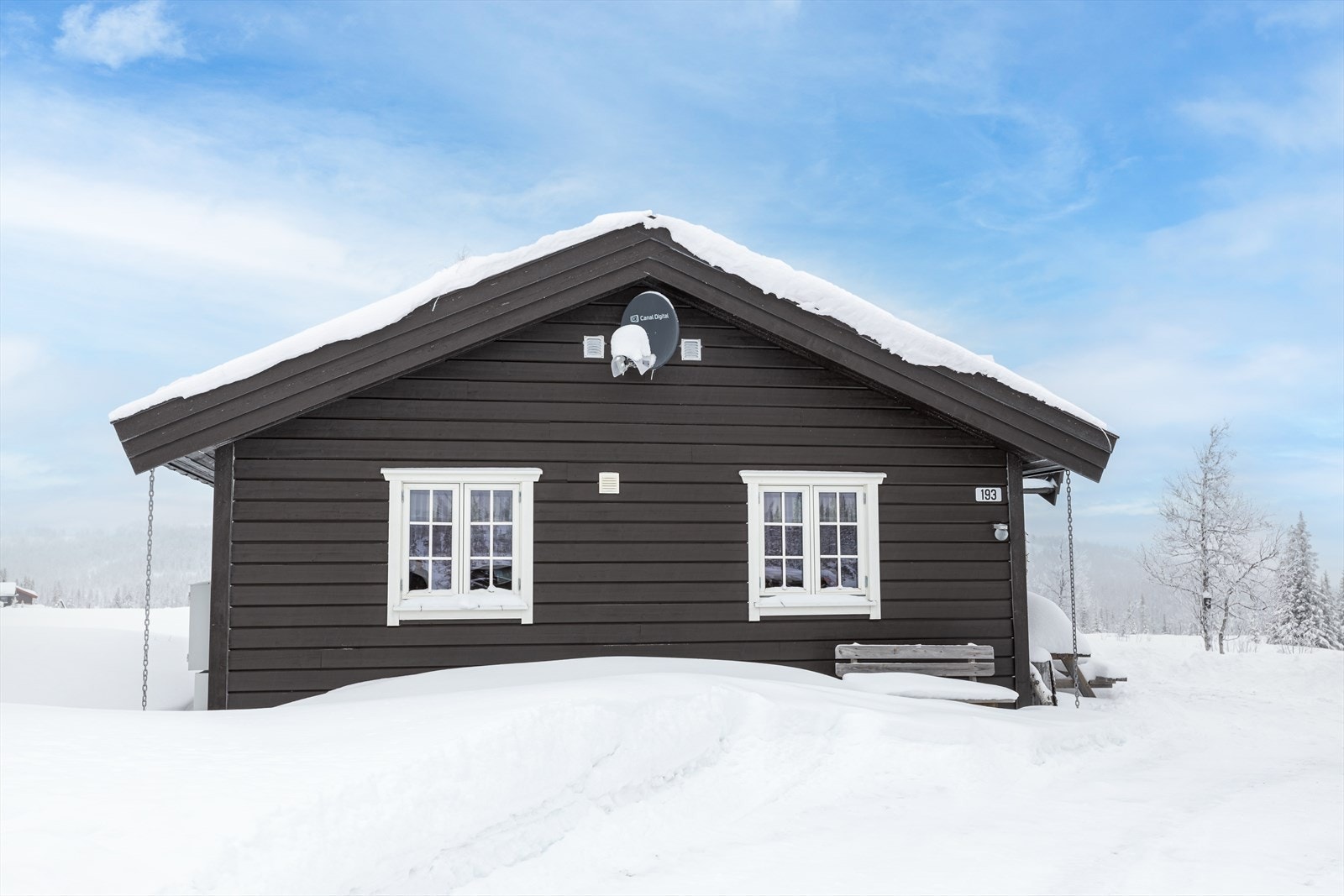 Helbeslått pipe og tre takrenner med kjetting som nedløp er synlige på boligen. Galleribilde
