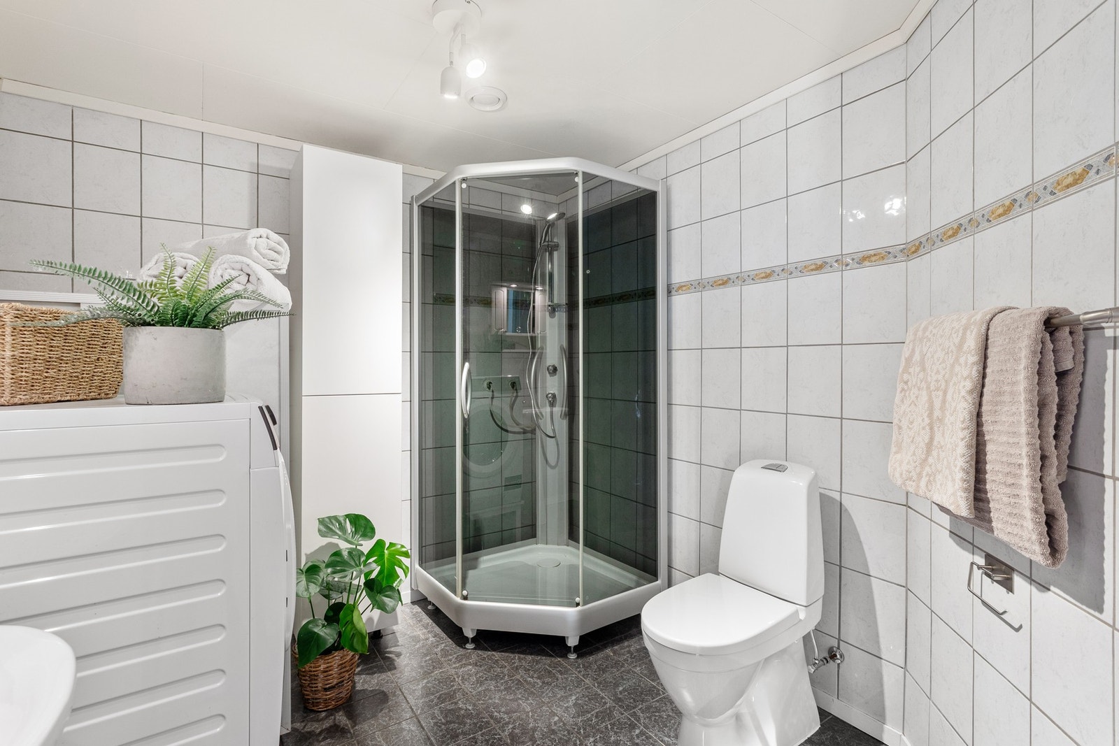 Badet er utstyrt med dusjkabinett, varmtvannsbereder og opplegg til vaskemaskin. Galleribilde