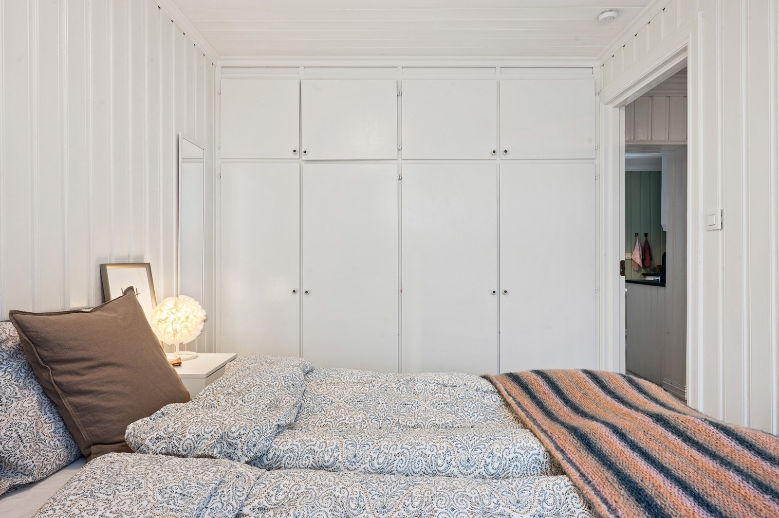 En hel vegg med plassbygde garderobeskap gir rikelig med oppbevaringsplass. Galleribilde