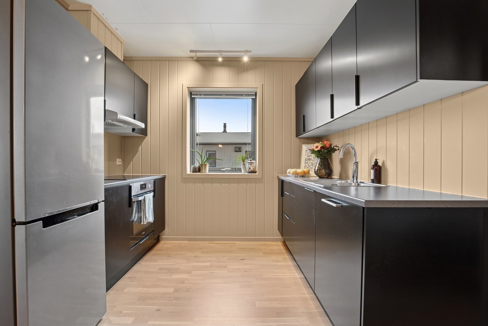 Stilrent kjøkken med praktiske løsninger og god skapplass. Galleribilde