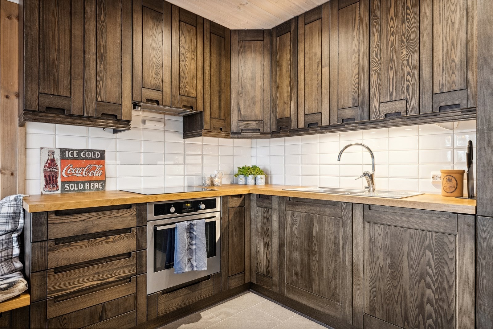 Kjøkkenet består av integrerte hvitevarer, profilerte under- og takhøyeoverskap i heltre. Samt flislagt gulv og flis over bankeplaten. Benkeplaten i seg selv er av heltre eik. Galleribilde