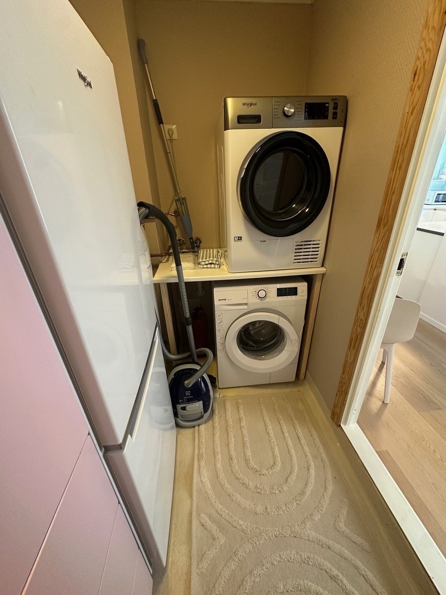 Vaskerom med tørketrommel, vaskemaskin, ekstra kjøleskap og ekstra skap til oppvaskmidler og diverse. Galleribilde