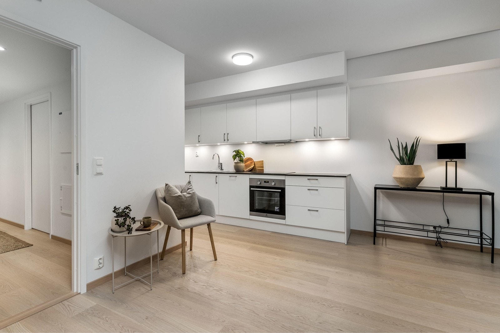 Lekkert kjøkken i åpen løsning mot stue, med integrerte hvitevarer Galleribilde