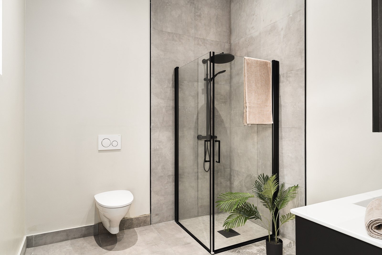 Badet inneholder: Vegghengt toalett, helstøpt servant, skuffer under servant med slette fronter, dusjdører i klart glass. Galleribilde