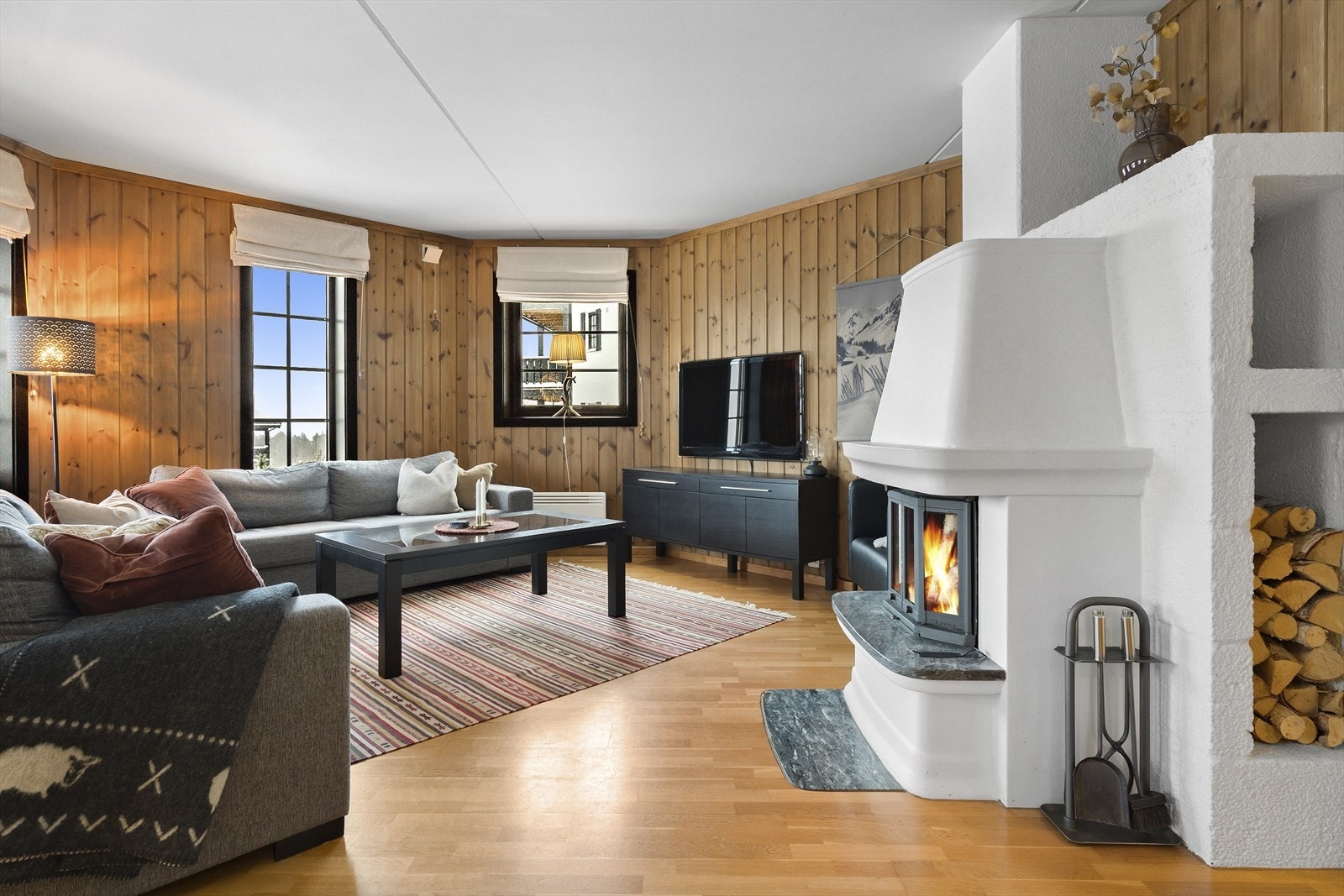 Leiligheten har lekkert trepanel og mange vinduer som slipper inn godt med naturlig lys Galleribilde