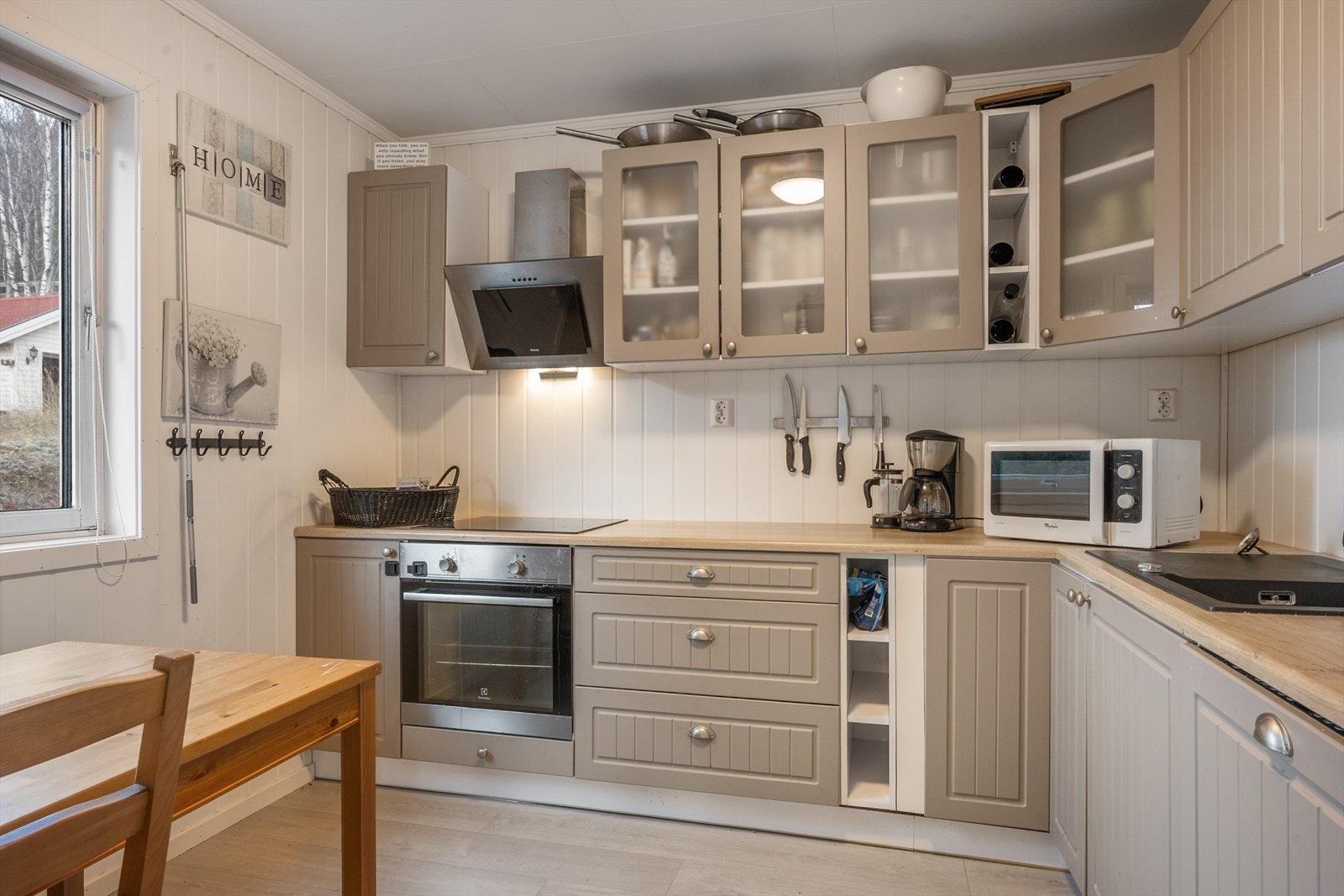 Kjøkkenet har malt innredning med profilerte fronter og benkeplate i laminat. Galleribilde