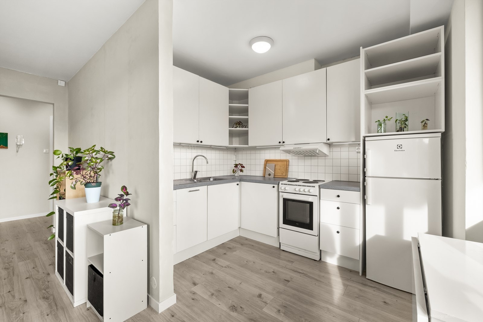 Klassisk kjøkkeninnredning med hvite slette fronter og benkeplate av laminat. Galleribilde