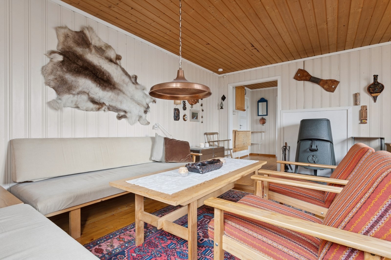 Lun og lys stue med gjennomført hyttestil og vinduer som slipper naturen inn. Galleribilde