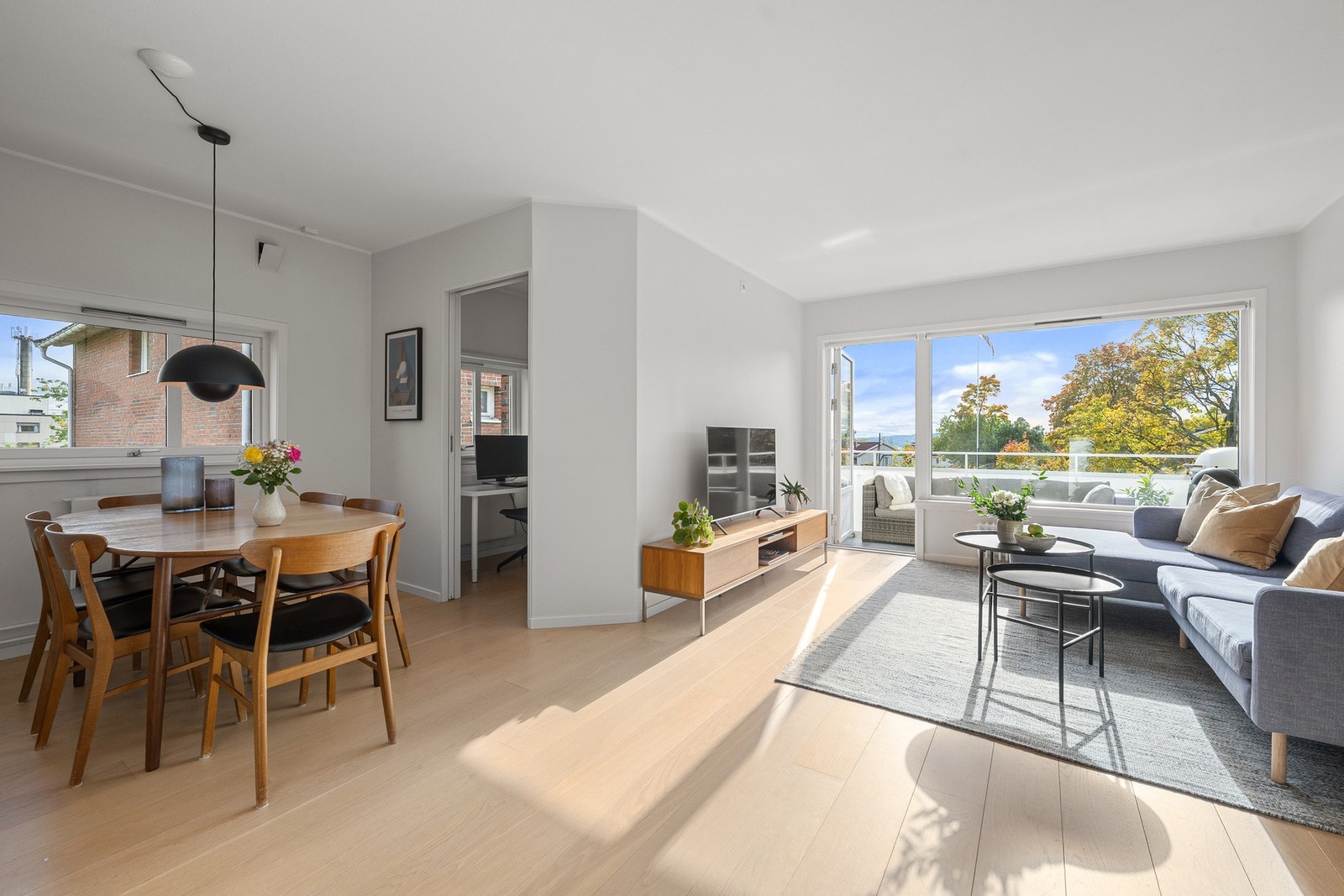 Videre inn i en lys og luftig stue med plass til både sofa og spisebord. Galleribilde