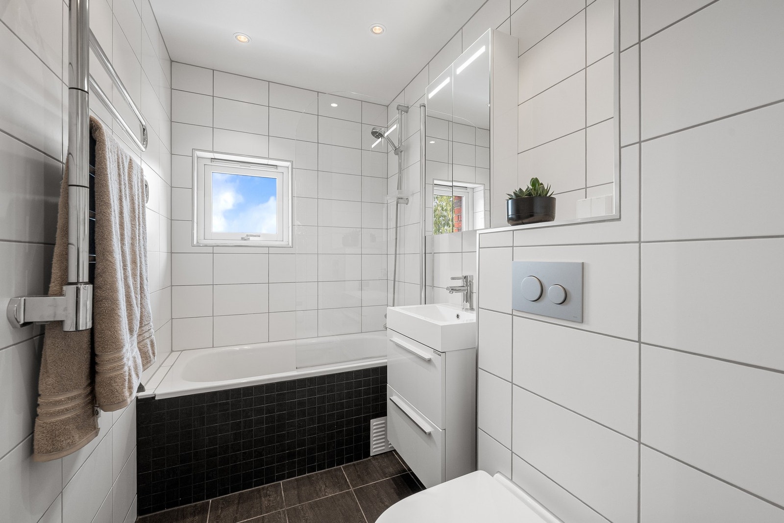 Badet er fra 2016 og har fliser på vegger og gulv, gulvvarme, innebygget badekar med dusj. Galleribilde