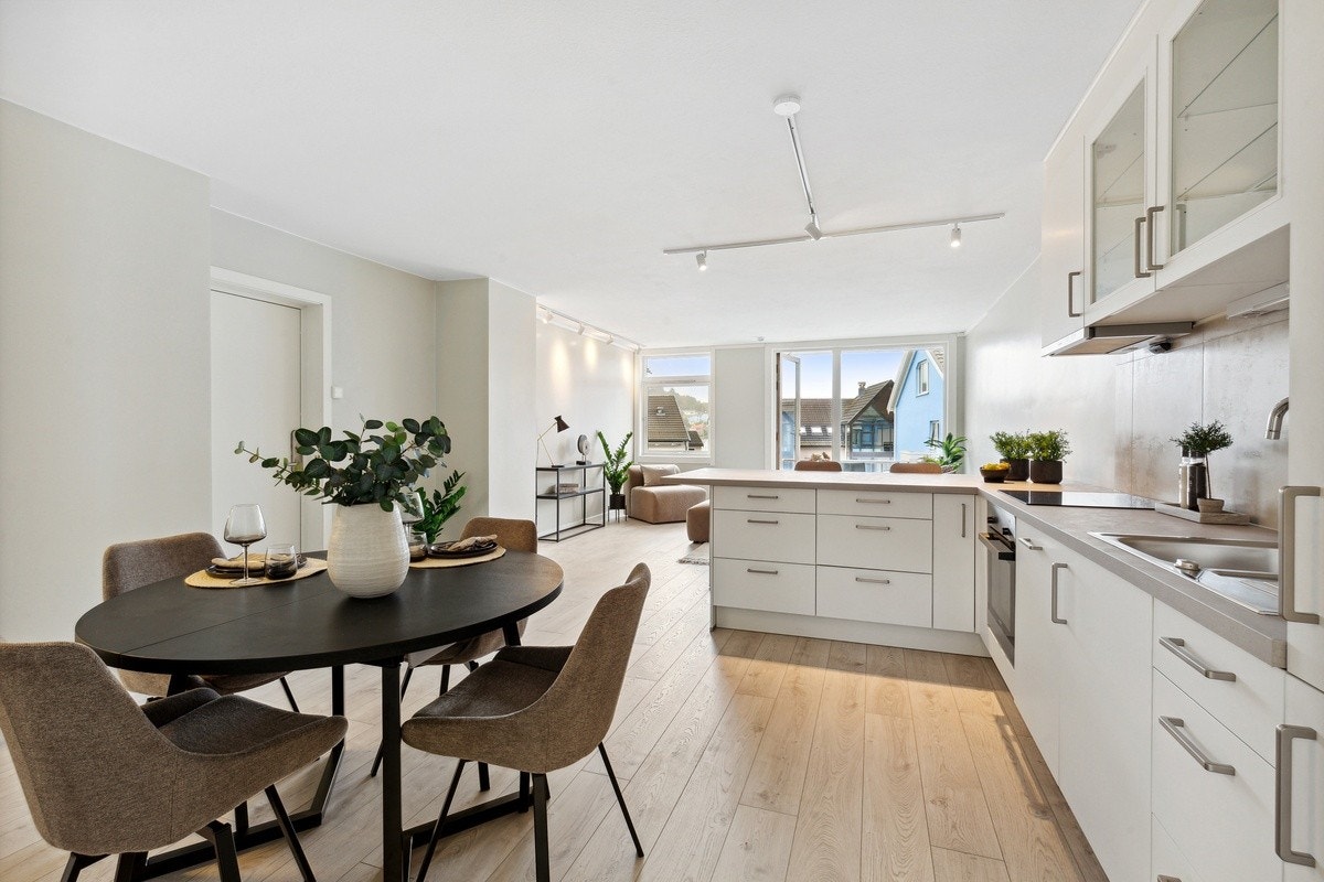 Leilighetens oppholdsrom, med en åpen løsning mellom stue og kjøkken, er adskilt med en kjøkkenøy Galleribilde