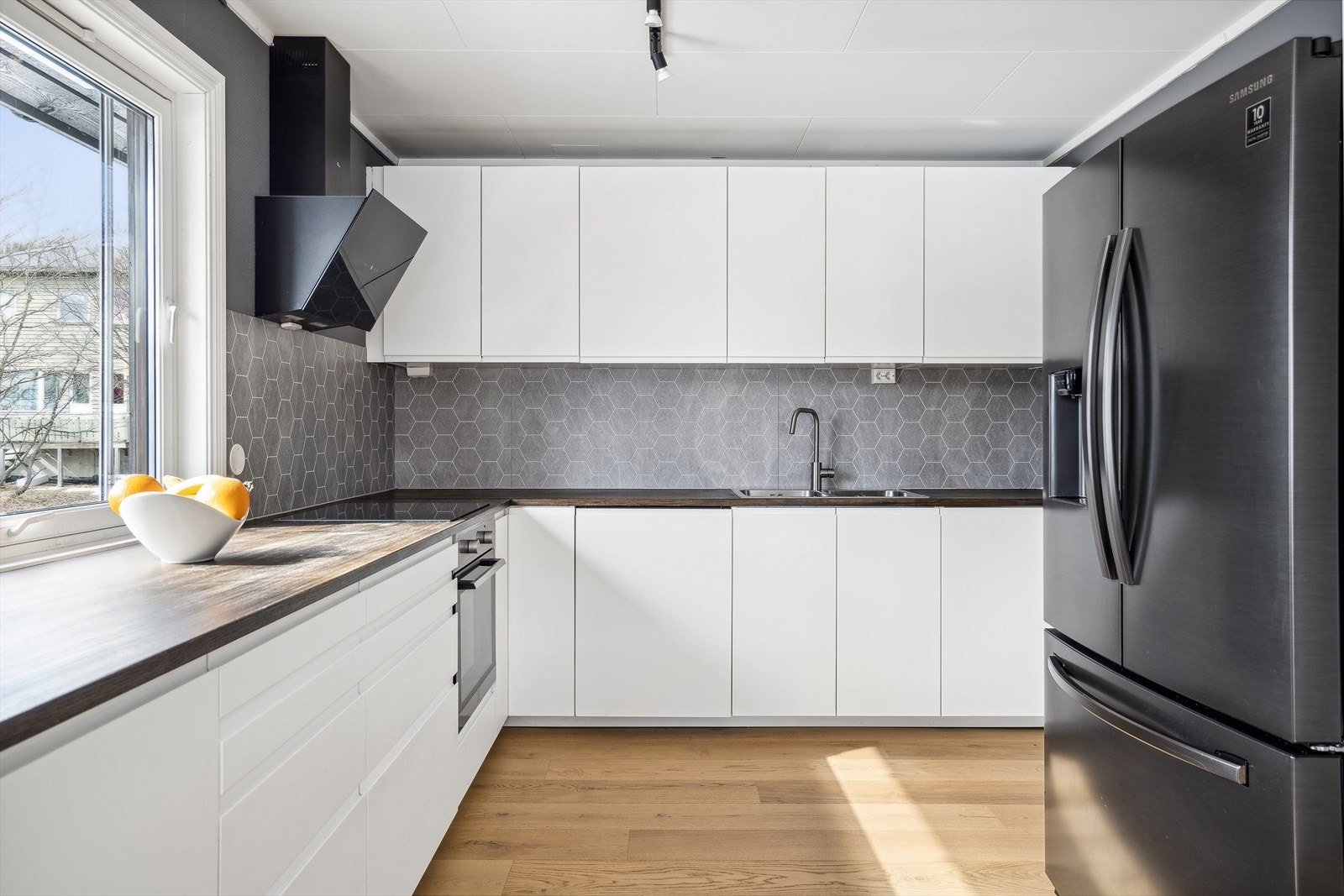 Stilrent og romslig kjøkken med mye skap- og benkeplass. Galleribilde