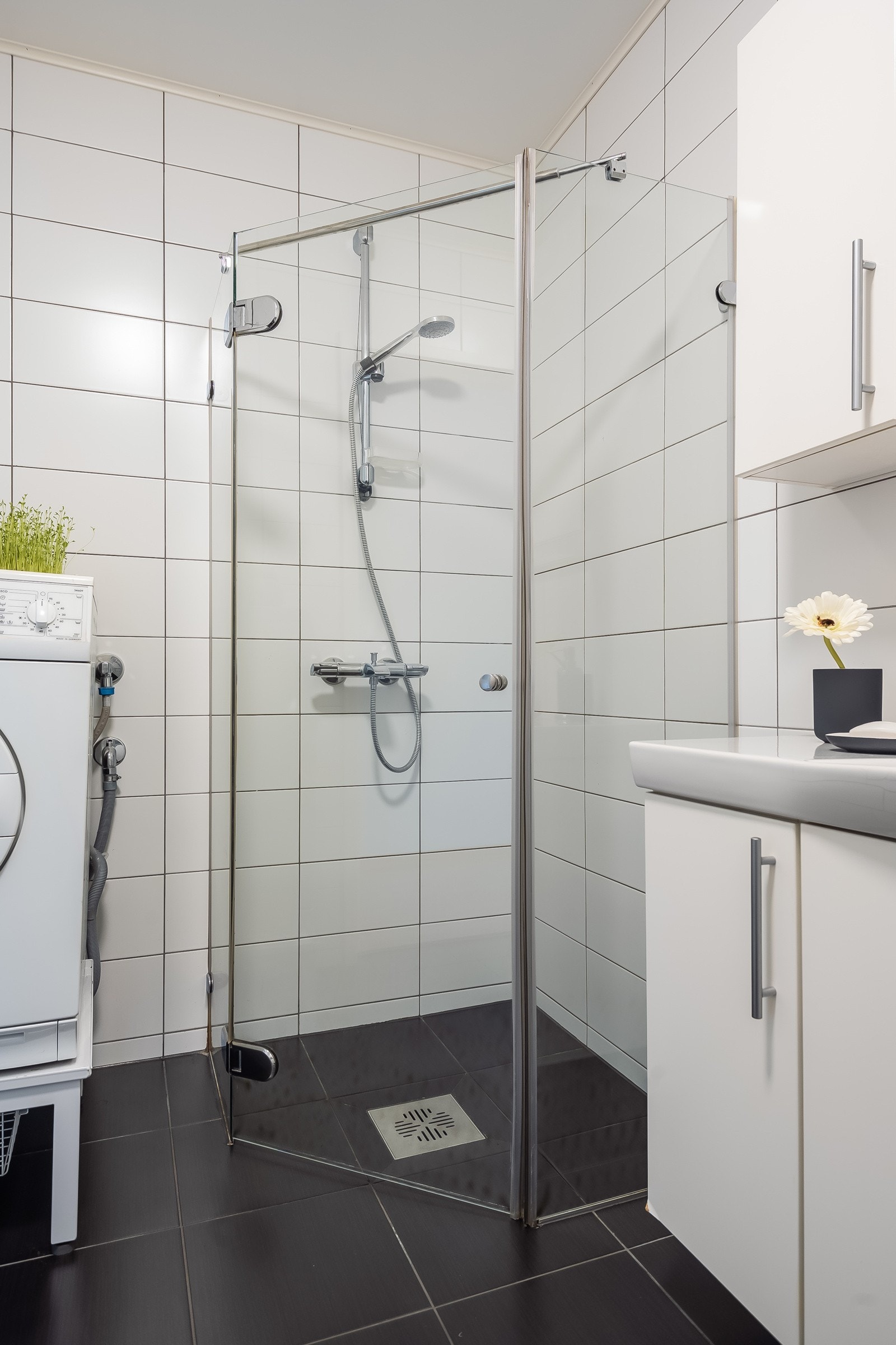 Badet er utstyrt med stor baderomsinnredning, toalett, dusjhjørne med innfellbare dusjdører og opplegg for vaskemaskin. Galleribilde