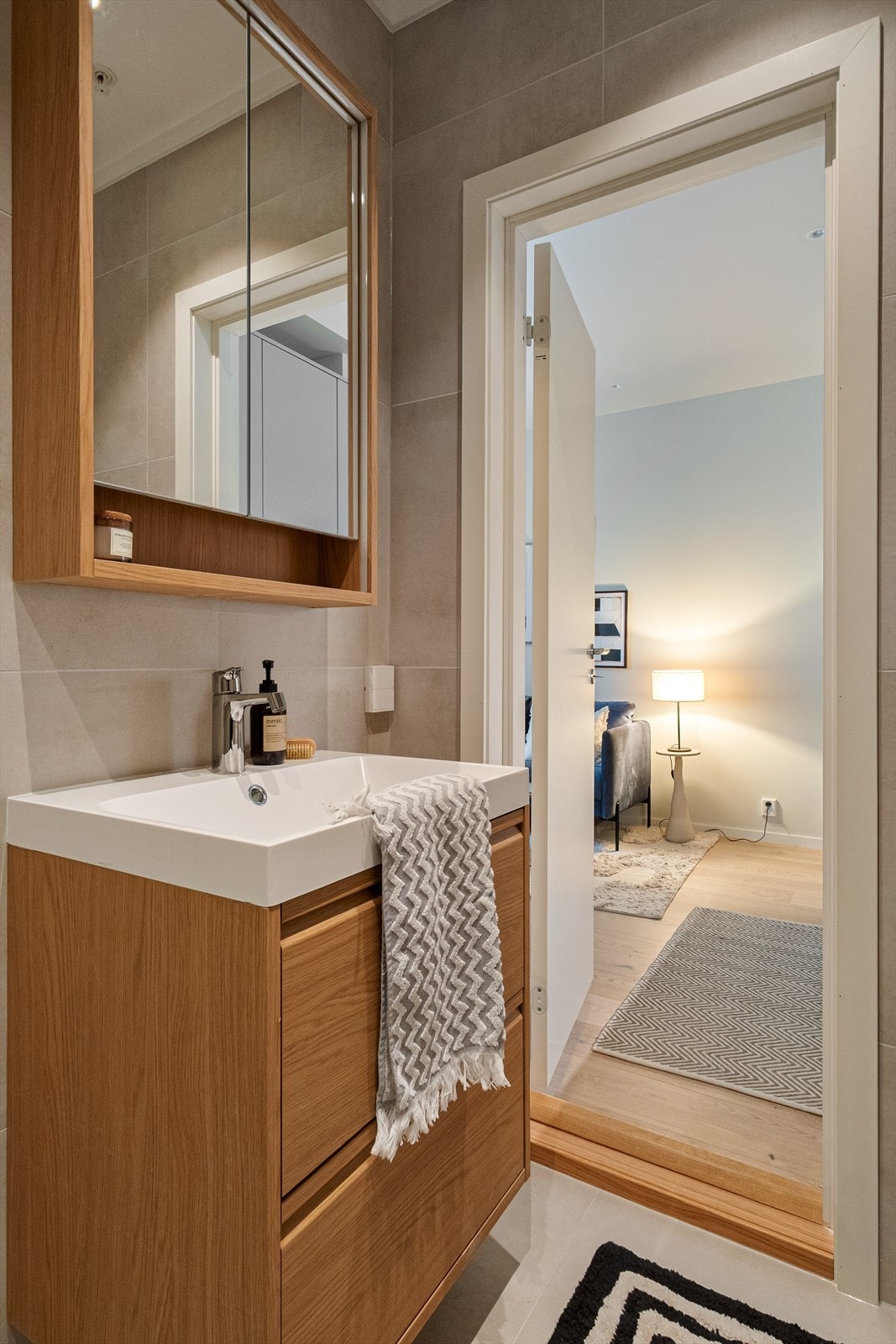 Baderommet er innredet med vegghengt klosett, servant nedfelt i innredning, speilskap m/lys og dusjhjørne med svingbare glassdører. Mekanisk avtrekk. Galleribilde