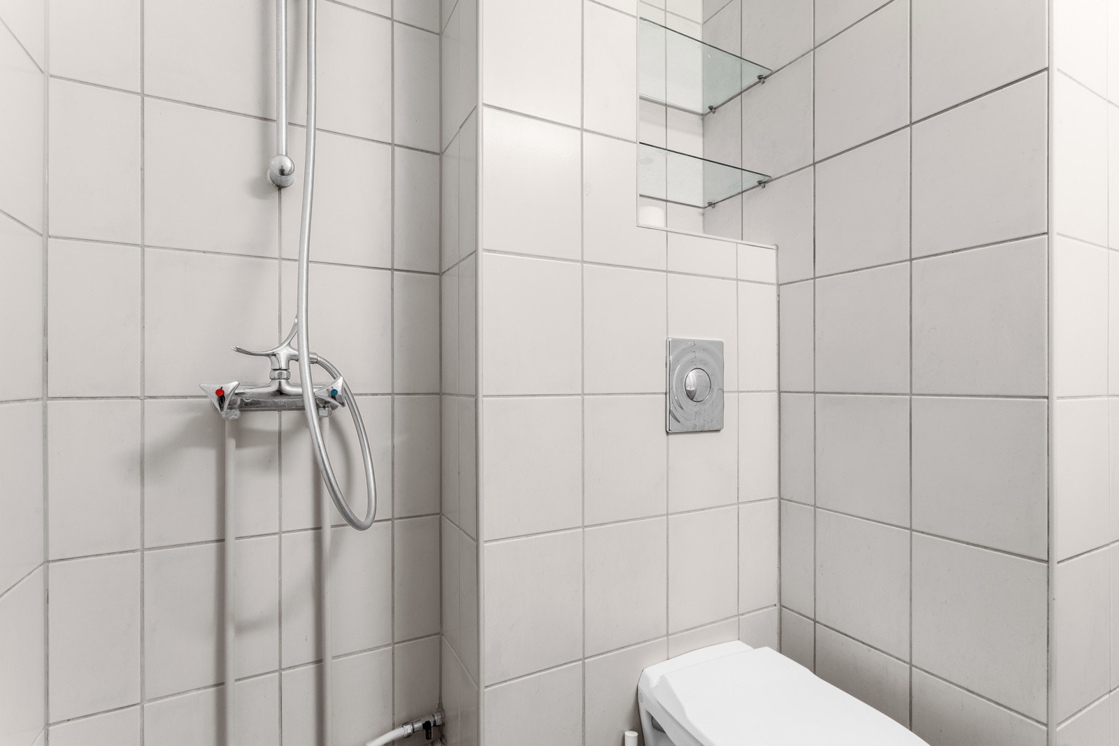 Over det vegghengte toalettet er det satt opp en hylleløsning av glassplater som gir deg oppbevaringsmuligheter for hygieneartikler og håndklær. Galleribilde