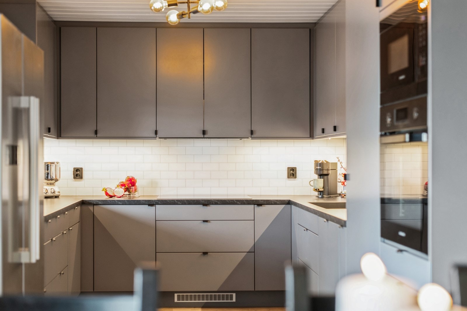 Det er fliser samt lys mellom over og underskap. Galleribilde