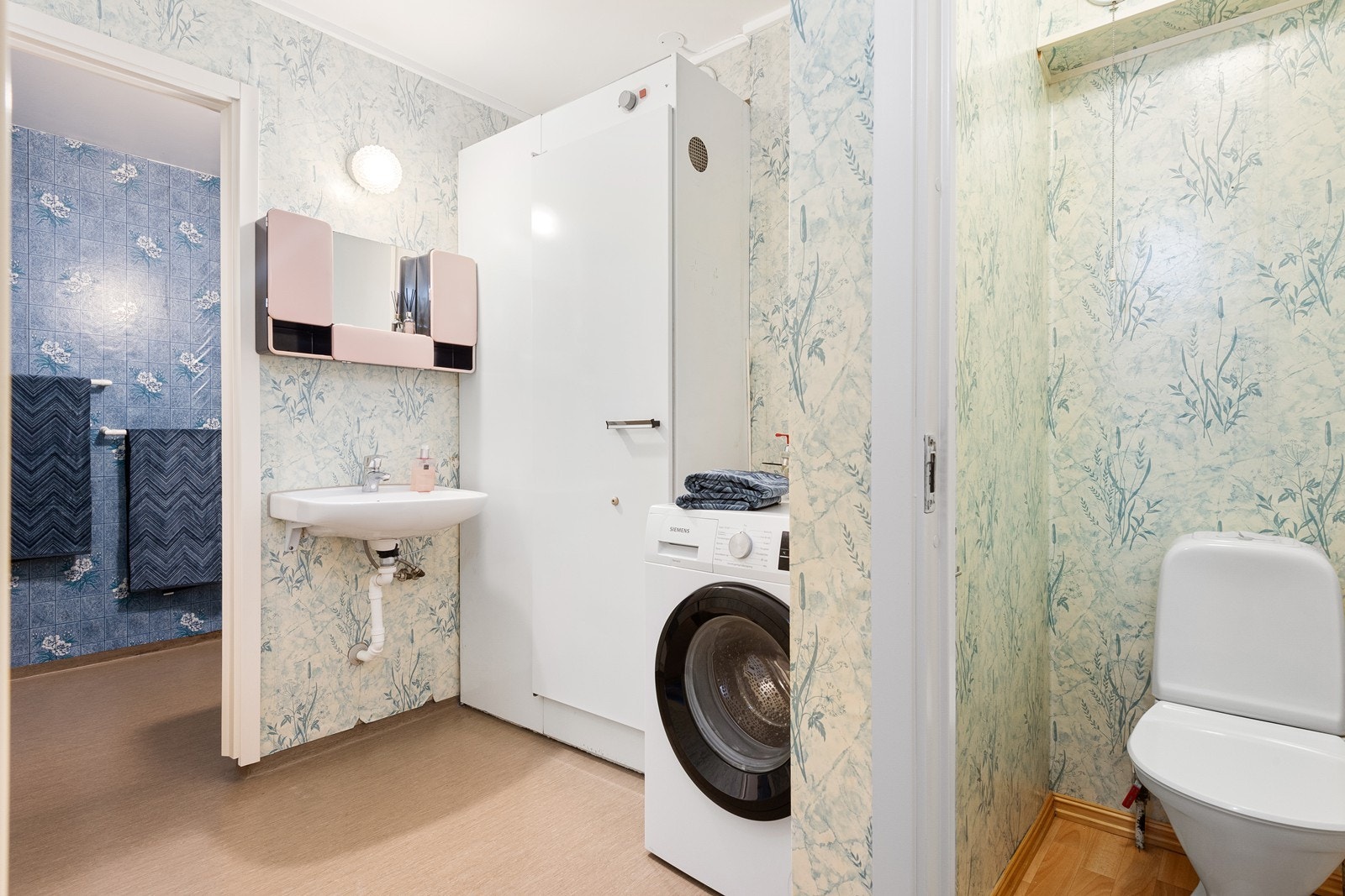 Baderommet har en tredelt løsning fra byggeår, bestående av bad, vaskerom og separat toalettrom. Bad og vaskerom har gulv med belegg og vegger kledd med våtromstapet. Galleribilde