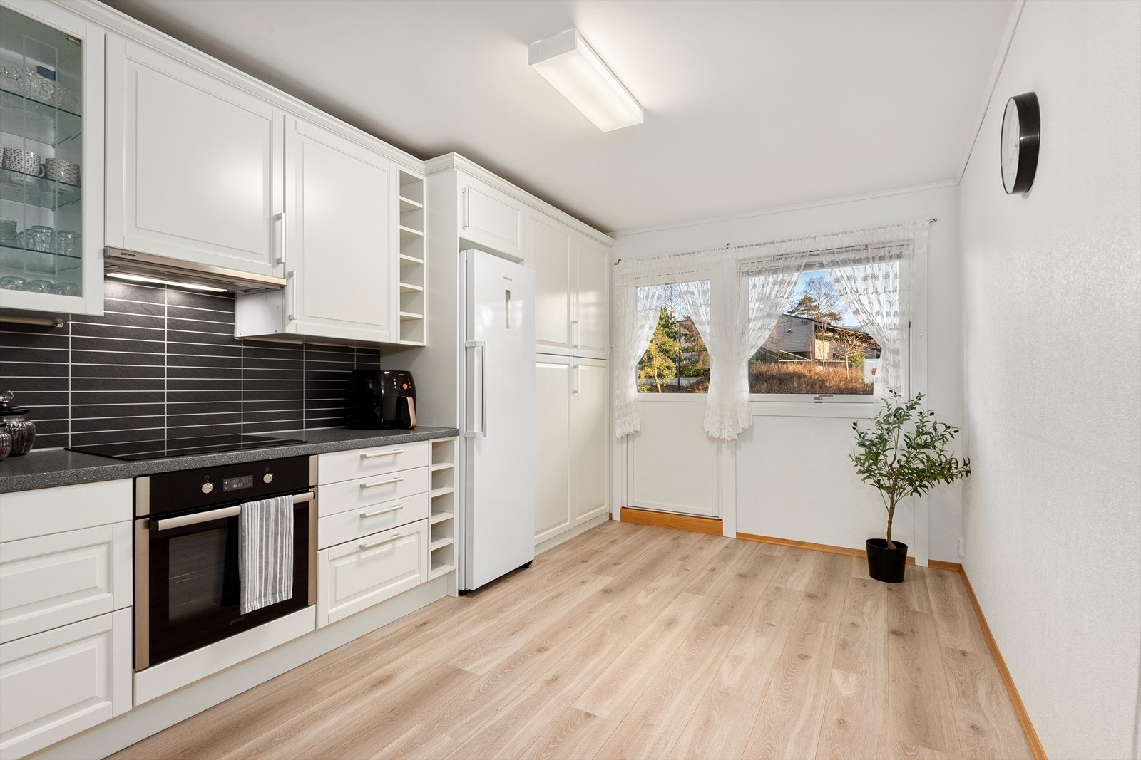 Løsningen byr på rikelig med skapplass, gode arbeidsflater og detaljer som glasskap og åpne hyller. Rommet har plass til spisebord og herfra er det utgang til en østvendt balkong. Galleribilde