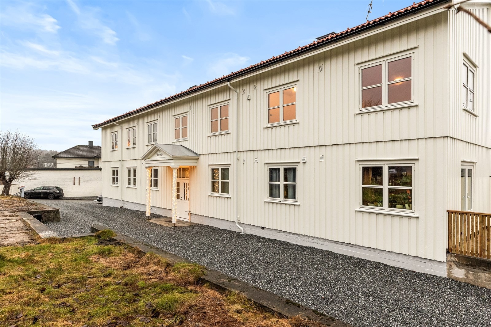 Gruset gårdsplass med avsatt plass til en bil for hver seksjon. Galleribilde