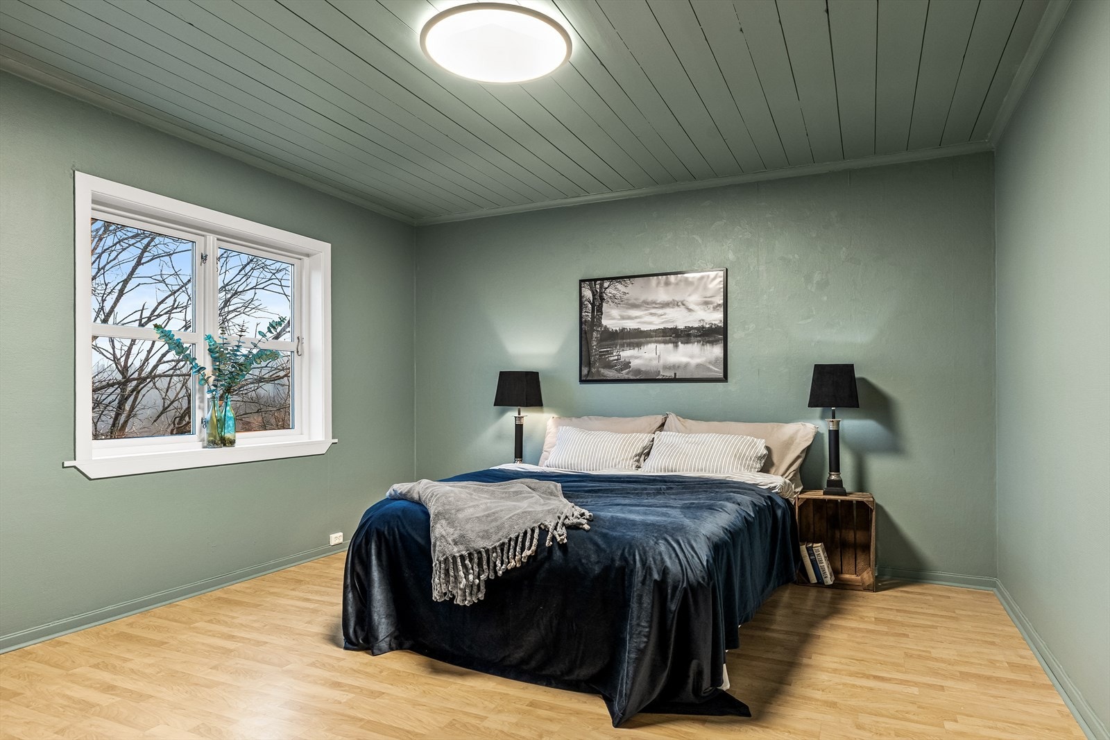 Romslig soverom malt i lun dempet grønnfarge. Garderobeskap på soverom. Galleribilde