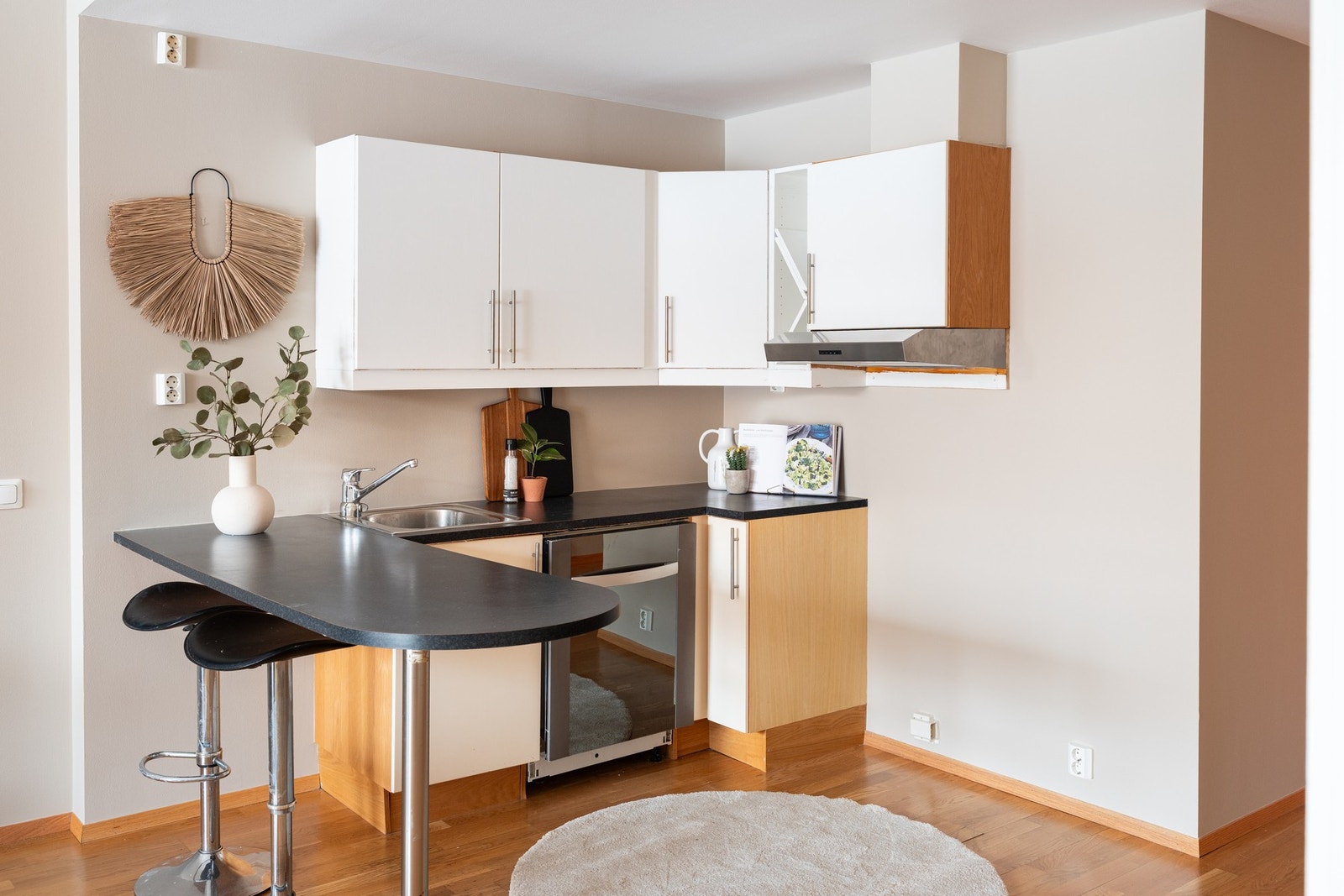 Lyst kjøkken med slette fronter og praktisk kjøkkenøy som sikrer ekstra arbeidsflate. Galleribilde