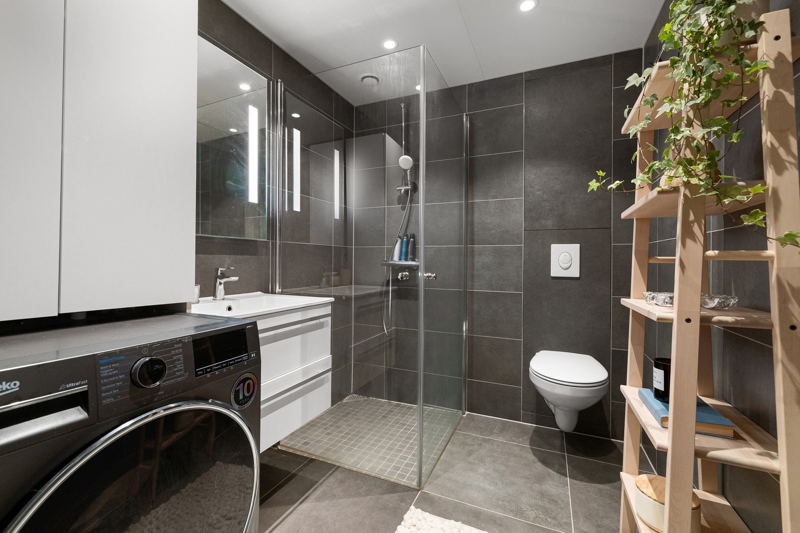 Lekkert baderom fra 2023 med behagelige varmekabler i gulv og opplegg for vaskemaskin. Galleribilde