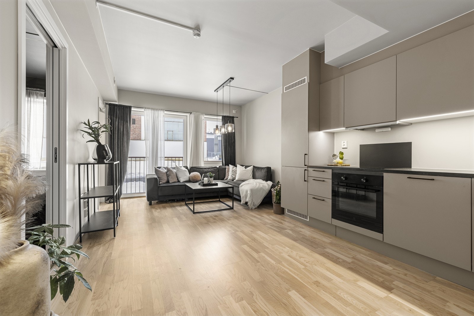 Den åpne løsningen mellom stue og kjøkken gir en sosial og luftig atmosfære. Galleribilde