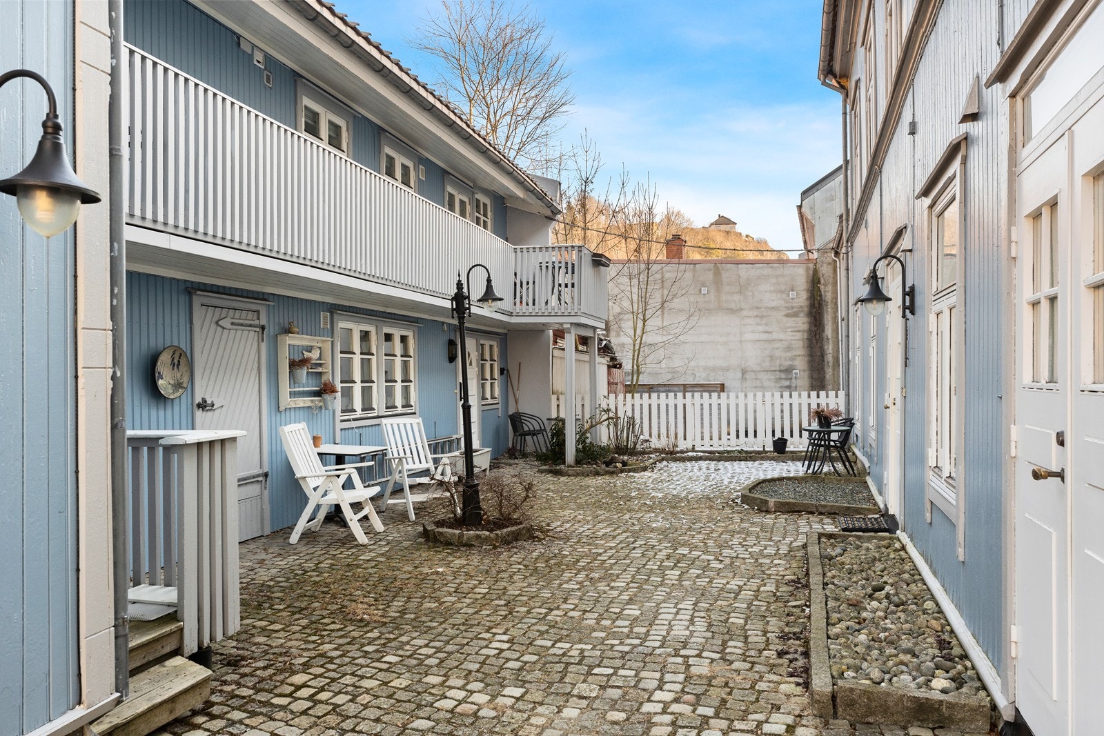 Felles gårdsrom for sameiet opparbeidet med brostein og delvis beplantning. Galleribilde