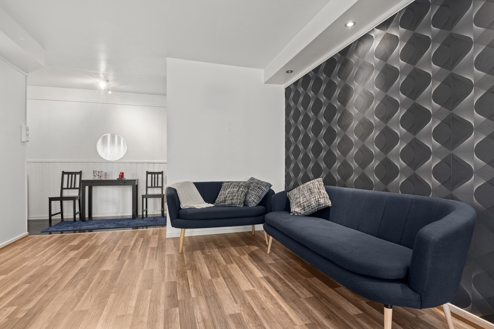 Stuen har lyse og fine farger sammen med en vegg som er tapetsert. Galleribilde