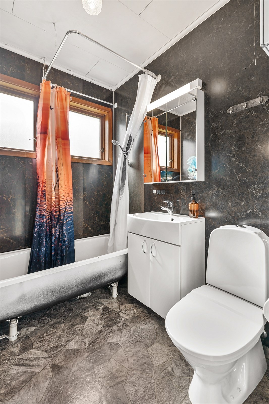 Bad med nedfelt servant, toalett og badekar. Galleribilde