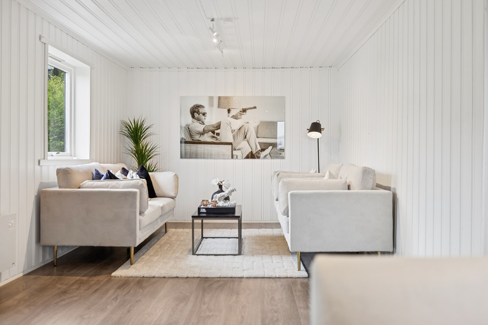 Gjennomgående laminatgulv og lyse panelvegger skaper en helhetlig stil. Galleribilde