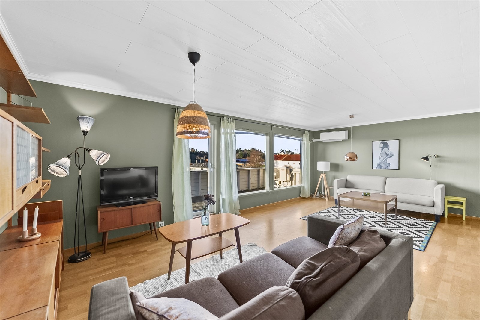 Lys stue med gode vindusflater. I stua er det montert en varmepumpe og en vedovn. Utgang til terrassen i front og på siden. Galleribilde