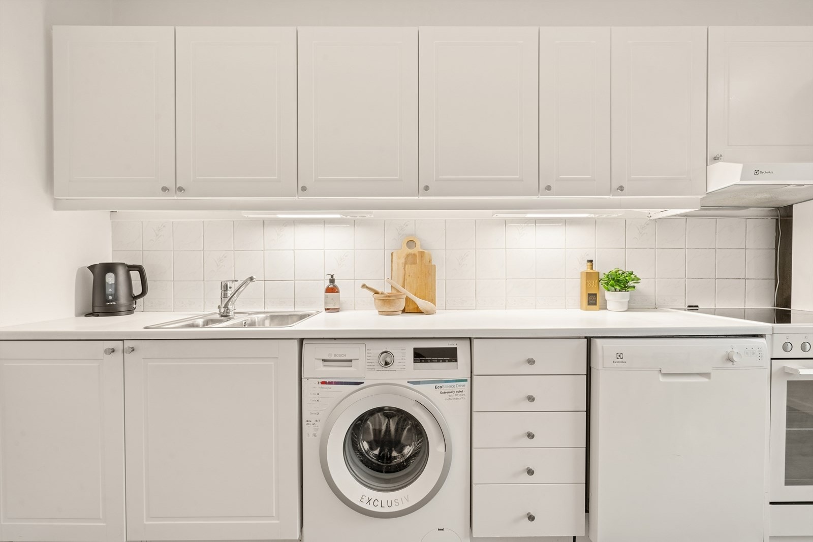 Kjøkkenet er utstyrt med profilerte fronter og en laminert benkeplate med nedfelt oppvaskkum i rustfritt stål. Galleribilde