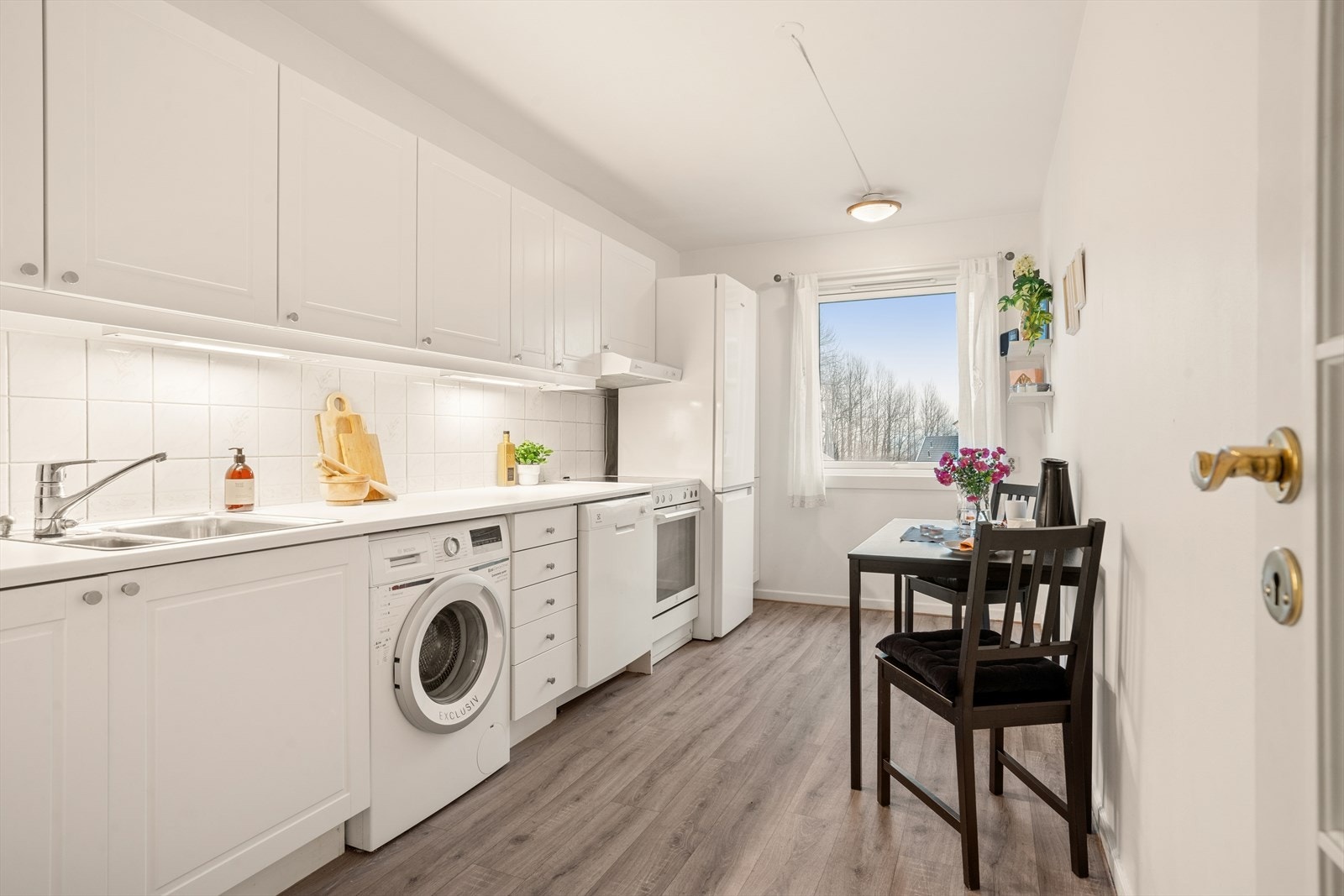 Separat kjøkken med adkomst fra inngangen. Hyggelig kokkelering tilbys under utsyn fra den store vindusflaten og god romfølelse med rikelig benk- og skapplass. Galleribilde