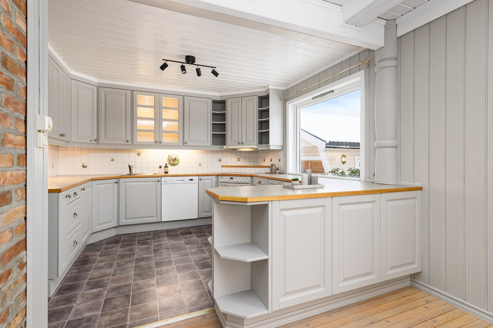 Pen kjøkkeninnredning med profilerte fronter og benkeplate av laminat med kantlist av eik. Galleribilde