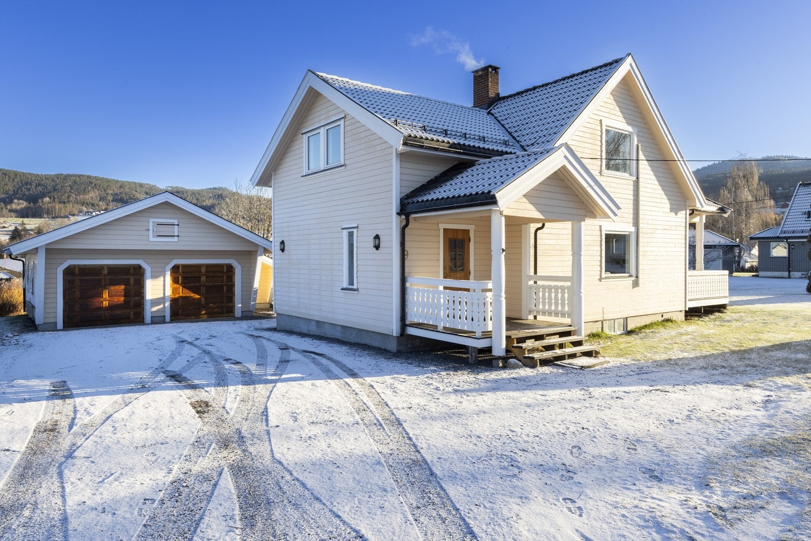 Tomten består av gruset gårdsplass og beplantet hage Galleribilde