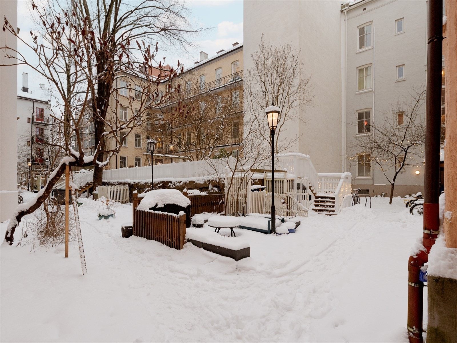 På sommerstid er bakgården frodig og fin. Området er utstyrt med sittebenker, plantekasser og sykkelparkering. Galleribilde