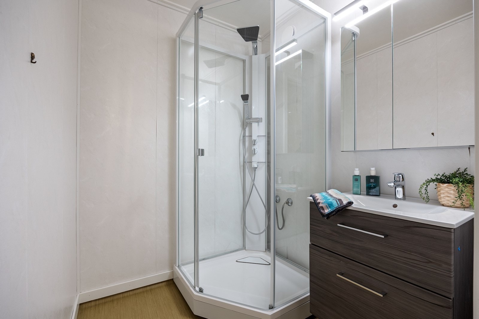 Baderom med nyere gulv, dusjkabinett og baderomsmøblement Galleribilde