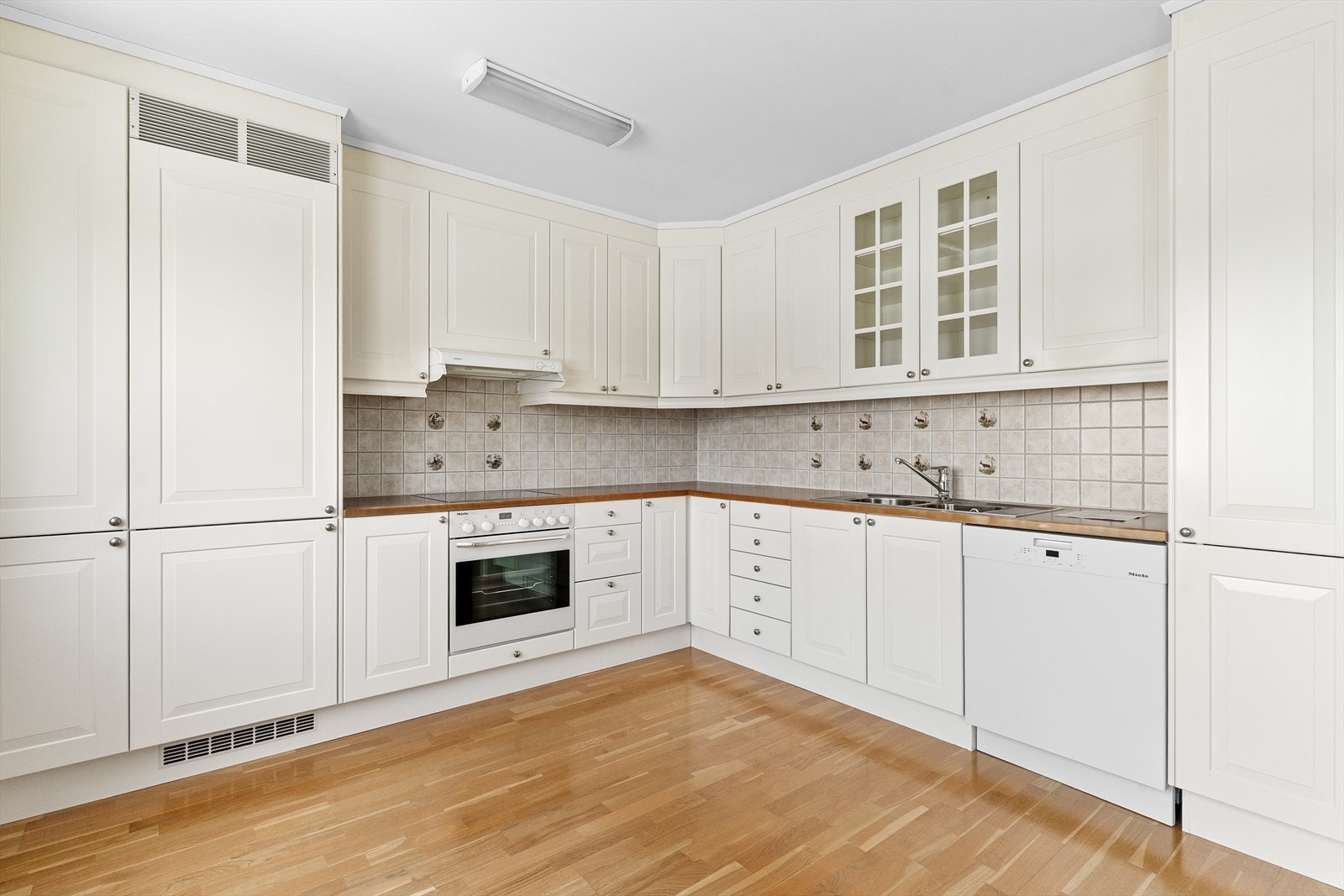 En gjennomtenkt plassering av elementene gjør kjøkkenet til et praktisk og hyggelig sted å lage mat. Innredningen byr på effektive arbeidsflater og god plass til oppbevaring i skuffer og skap. Galleribilde