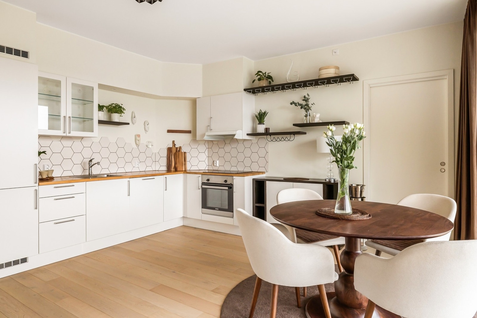 Kjøkkenet fremstår tidløst og moderne med lyse slette fronter og laminert benkeplate Galleribilde