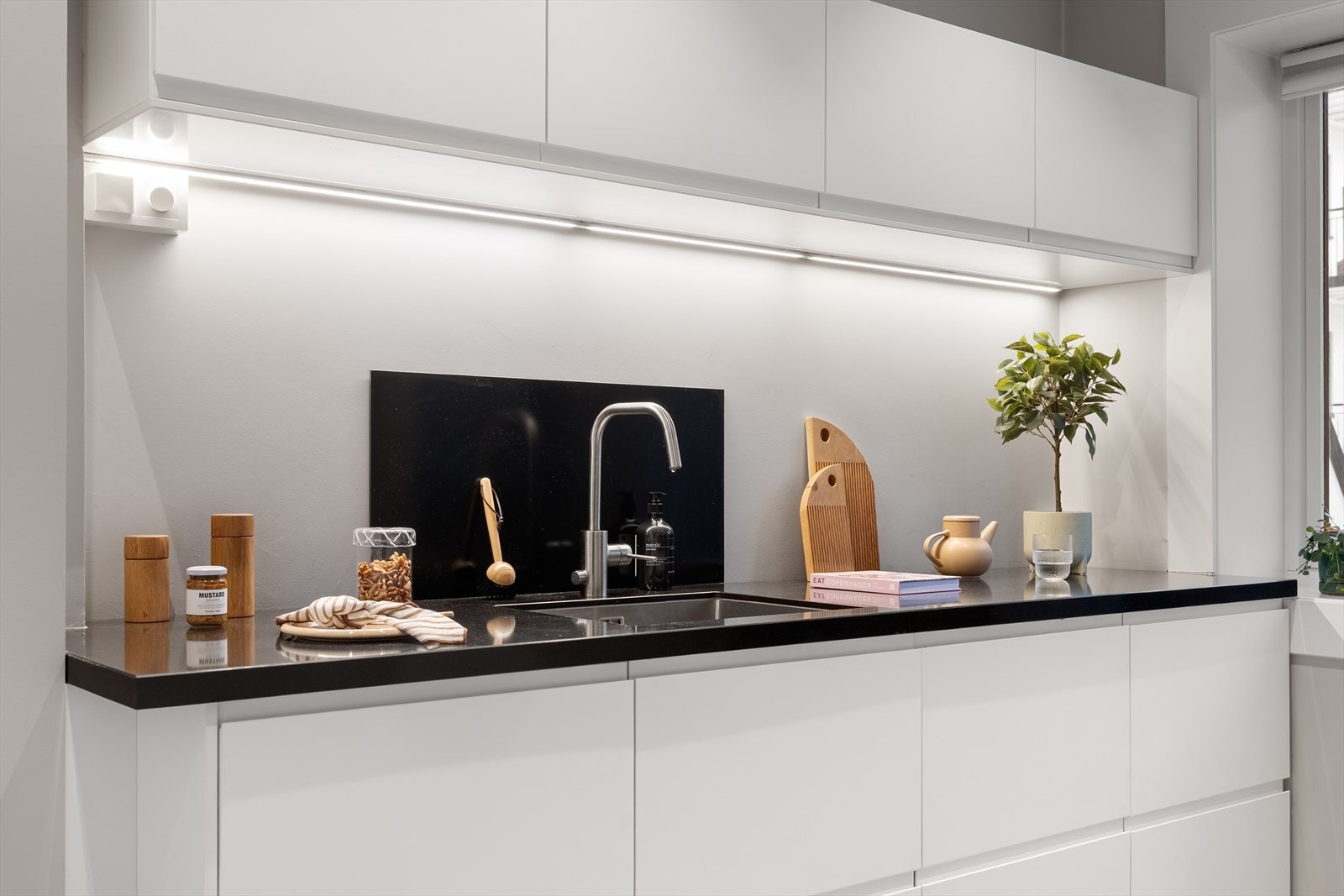 Kompositt benkeplate med integrert oppvaskkum og ettgreps blandebatteri gir gode arbeidsforhold, og belysning under overskap sørger for godt arbeidslys. Galleribilde